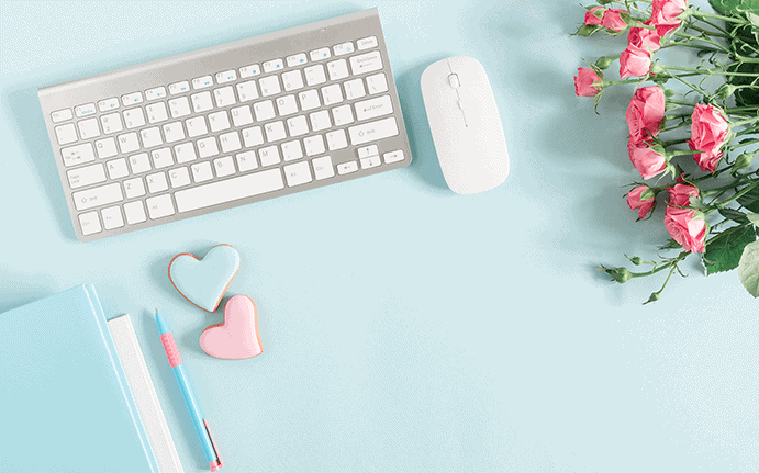 a white keyboard and mouse with flowers on a blue table